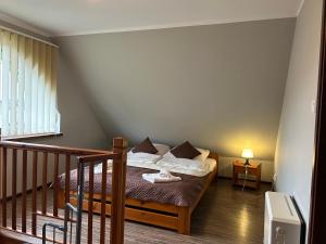 a small bedroom with a bed and a staircase at Apartamenty Antonio in Kudowa-Zdrój