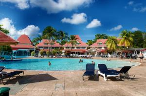 a pool at a resort with people swimming at Studio OLIA - plages, piscines et vue mer! in Sainte-Anne
