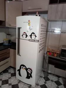 una nevera con pingüinos en la cocina en Casa em berlinque, vera cruz. en Vera Cruz de Itaparica