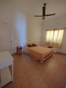een slaapkamer met een bed en een plafondventilator bij Limón Dulce Hostel in San Fernando del Valle de Catamarca