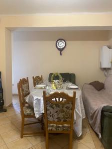 ein Esszimmer mit einem Tisch und einer Uhr an der Wand in der Unterkunft Vila ,Квартира на земле с террасой in Chişinău