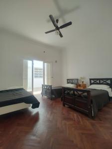 um quarto com 2 camas e uma ventoinha de tecto em Limón Dulce Hostel em San Fernando del Valle de Catamarca