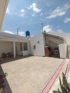 ein weißes Haus mit einer Terrasse und einer Auffahrt in der Unterkunft Limón Dulce Hostel in San Fernando del Valle de Catamarca