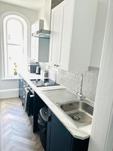 a kitchen with blue cabinets and a sink at Eden Hotel - Beach Apartments & Suites in Saint Helier Jersey