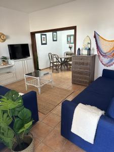 a living room with a blue couch and a table at SONRYE Graciosa in Caleta de Sebo