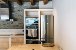 a kitchen with a stainless steel refrigerator and a wooden table at Mas Cal Rus in Alp