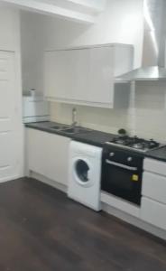 a kitchen with a stove and a washing machine at Ensuite room in West Midlands in Parkside