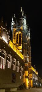 a large building with a clock tower at night at Appartement Loft haut standing in Douai
