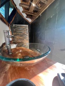 baño con lavabo de cristal con grifo en Bongalow Hoodoo en Melipeuco