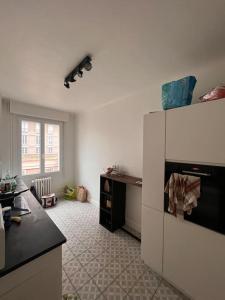 a kitchen with a white refrigerator in a room at Joli T2 en plein cœur du Havre in Le Havre