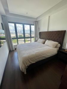 a bedroom with a large bed with a large window at Luxury Apartment, Harbour Bay in Jodoh