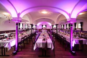 Oberstadion的住宿－Brauereigasthof Adler，紫色灯光的房间的一排桌子