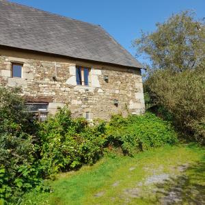 an old stone house with bushes in front of it at Le Calipel in Saint-Vigor-des-Monts