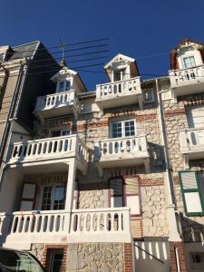 an old stone building with a white balcony at Villa Mon Etoile - Appartements 2 chambres, terrasse, Le Touquet, 200m centre-ville et plage in Le Touquet-Paris-Plage