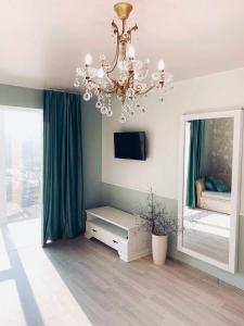 a living room with a chandelier and a mirror at Tiffany Apartment in Kropyvnytskyi