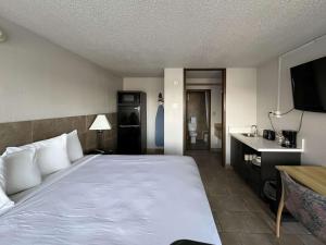 a hotel room with a large bed and a bathroom at Studio 6 Mesquite, TX Town East in Mesquite