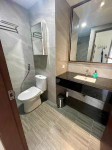 a bathroom with a toilet and a sink and a mirror at Luxury Apartment, Harbour Bay in Jodoh
