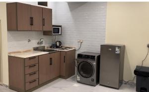 a kitchen with a stove and a washing machine at شقق كيان المخيم للشقق المخدومة in Najran