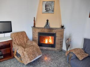 a living room with a fireplace with two chairs and a tv at Casa con chimenea-4 habit.-2 baños-Gran terraza in Alcanar