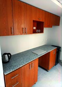 a kitchen with wooden cabinets and a counter top at Scandic Resort Apartment B 608 Hurghada in Hurghada