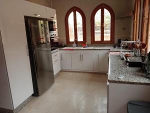 uma cozinha com armários brancos e um frigorífico de aço inoxidável em Marrakech em Marrakech