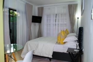 1 dormitorio con cama y mesa de cristal en Fafi's Place en Johannesburgo