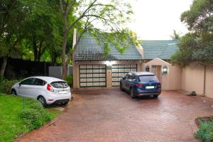 dos autos estacionados frente a un garaje en Fafi's Place en Johannesburgo