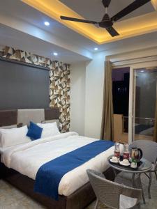 a bedroom with a large bed and a table at Tulip inn in Greater Noida