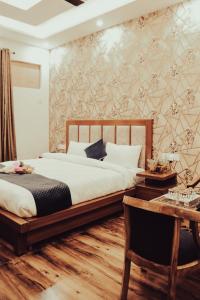 a bedroom with a bed and a wooden table and a desk at Tulip inn in Greater Noida