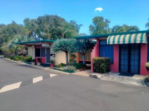 a building with palm trees in front of a street at Oakey Motel in Oakey