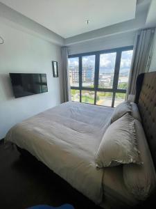 a bedroom with a large bed with a large window at Luxury Apartment, Harbour Bay in Jodoh