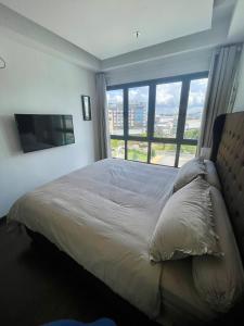 a bedroom with a large bed with a large window at Luxury Apartment, Harbour Bay Residences in Jodoh +7 photos