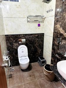 a bathroom with a toilet and a sink at Navarathna Comforts in Madikeri