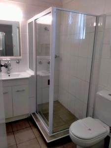 a bathroom with a shower and a toilet and a sink at Oakey Motel in Oakey