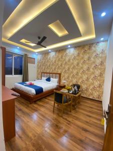 a bedroom with a bed and a desk and a table at Tulip inn in Greater Noida