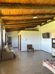 uma ampla sala de estar com tecto em madeira em Casa a 50 metros do mar em Itati