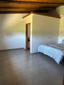 um quarto com uma cama e piso em azulejo em Casa a 50 metros do mar em Itati