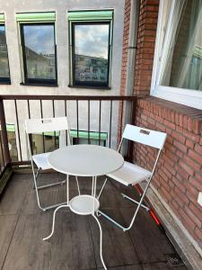 - Balcón con mesa blanca y 2 sillas en BSS Wohnungen en Bremen