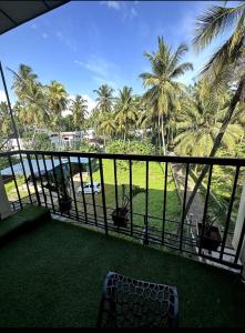 a balcony with a view of the ocean and palm trees at Rio Rooms Calicut in Kozhikode