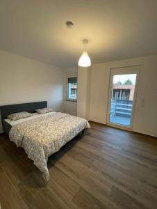 1 dormitorio con cama y ventana grande en Fancy Big Apartment, en Gerasdorf bei Wien