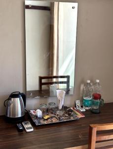 a table with a mirror and some glasses on it at Rio Rooms Calicut in Kozhikode