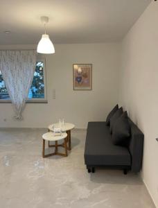 a living room with a black couch and a table at Fancy Big Apartment in Gerasdorf bei Wien