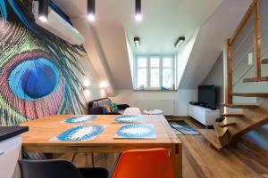 クラクフにあるCharming 2-Level Apartment - Podgórze, Old Townのテーブルと椅子、階段が備わる客室です。
