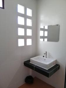 biała łazienka z umywalką i oknem w obiekcie Sinnlodge w mieście Nan