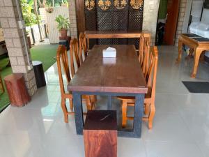 een houten tafel en stoelen in een restaurant bij Sinnlodge in Nan