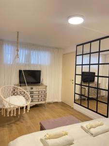 een woonkamer met een tv en een schommelbed bij Butikush in Haifa