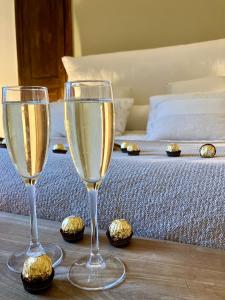 zwei Gläser Champagner auf einem Tisch neben einem Bett in der Unterkunft Appartement VH III in Le Mans