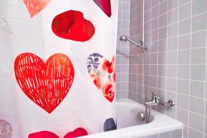 a shower curtain with hearts on it in a bathroom at Double Room by Interlaken. Parking in Därligen