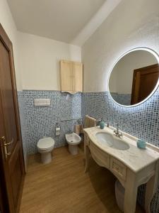 a bathroom with a sink and a toilet and a mirror at La Casina di Maya in Livorno