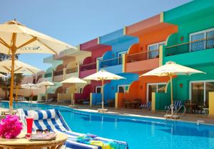 a pool at a hotel with chairs and umbrellas at Sierra Sharm El Sheikh in Sharm El Sheikh